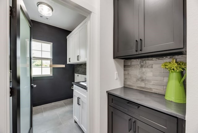 kitchen featuring gray cabinetry, white cabinets, tasteful backsplash, and light tile floors