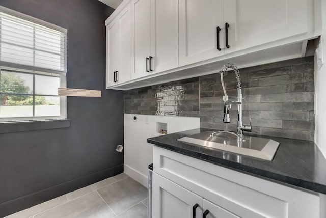 laundry area featuring cabinets, light tile flooring, washer hookup, sink, and hookup for an electric dryer