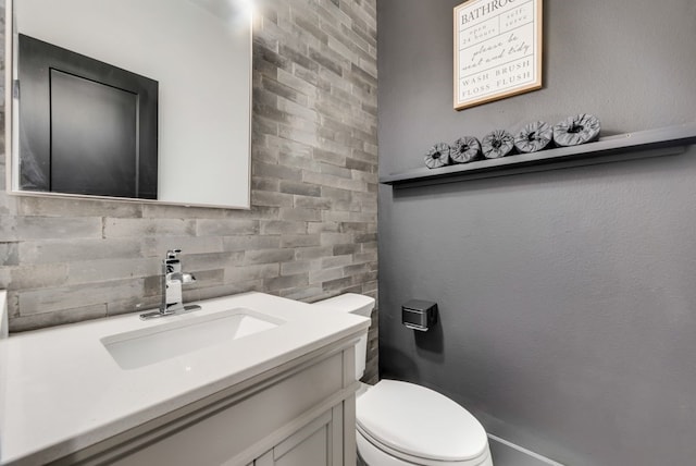 bathroom with tasteful backsplash, vanity, and toilet