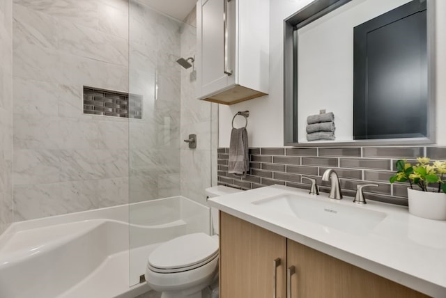 bathroom with toilet, vanity, and tasteful backsplash