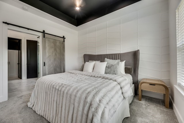 carpeted bedroom featuring a barn door and multiple windows