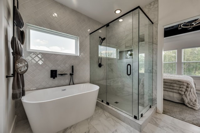 bathroom featuring tile floors, independent shower and bath, and tile walls