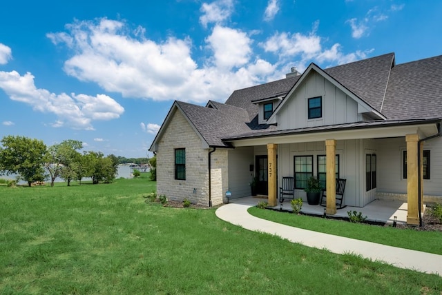 rear view of property featuring a porch and a lawn