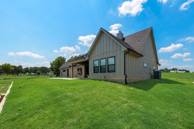 view of front of property featuring central AC and a front yard