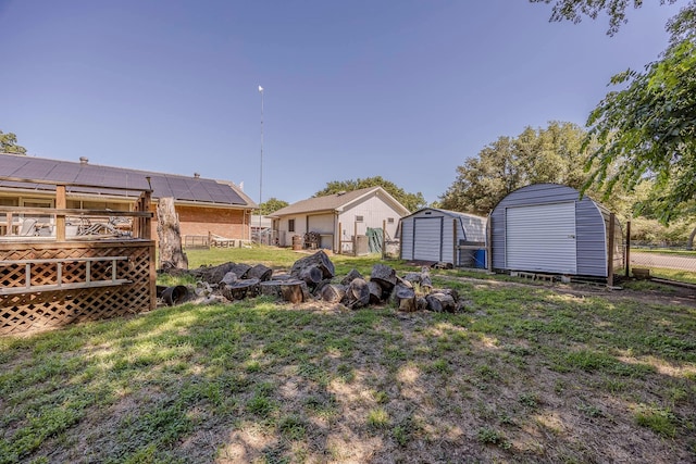 view of yard featuring a storage unit and a wooden deck