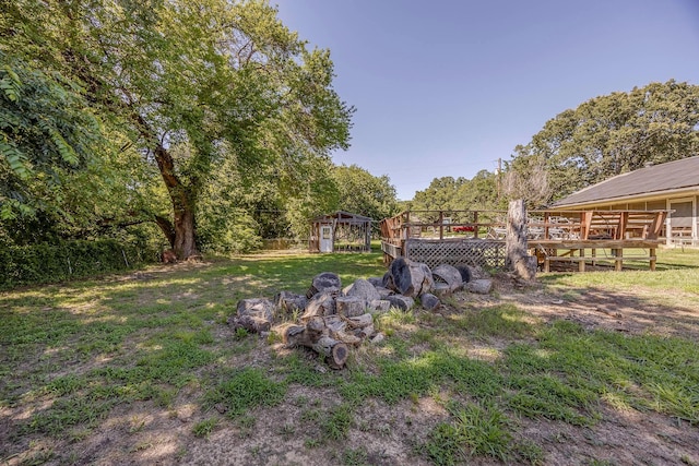 view of yard featuring a deck and an outdoor structure