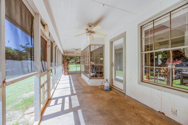 unfurnished sunroom featuring ceiling fan