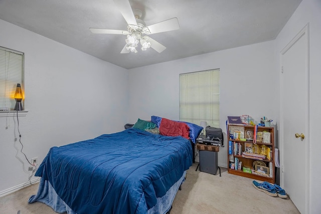 bedroom with ceiling fan and light carpet