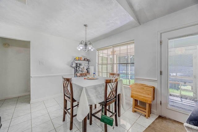 dining area with light tile patterned flooring, a healthy amount of sunlight, a textured ceiling, and an inviting chandelier