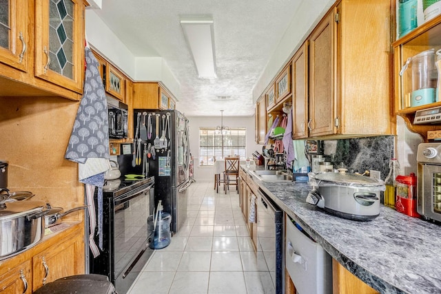 kitchen featuring backsplash, black appliances, sink, light tile patterned floors, and a notable chandelier