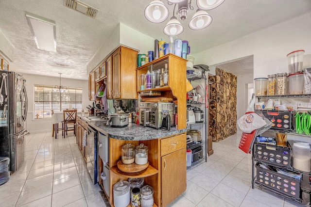 kitchen featuring light tile patterned flooring, a chandelier, a textured ceiling, and appliances with stainless steel finishes