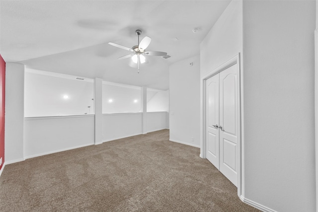 carpeted empty room featuring vaulted ceiling and ceiling fan