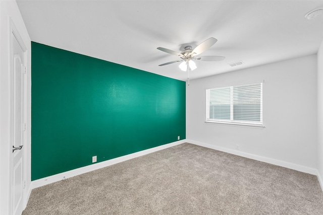 spare room featuring ceiling fan and carpet