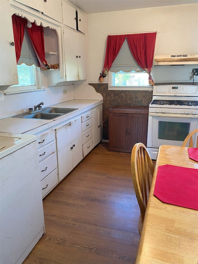 kitchen featuring premium range hood, white cabinetry, white gas range, and plenty of natural light