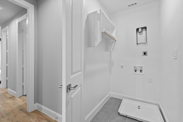 washroom with hookup for an electric dryer, hardwood / wood-style floors, gas dryer hookup, and hookup for a washing machine