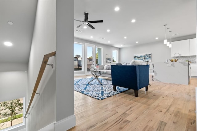 living room with light hardwood / wood-style floors and ceiling fan