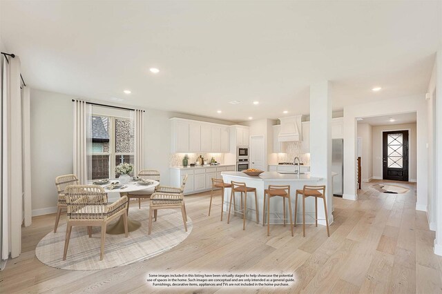 dining space with sink and light hardwood / wood-style flooring