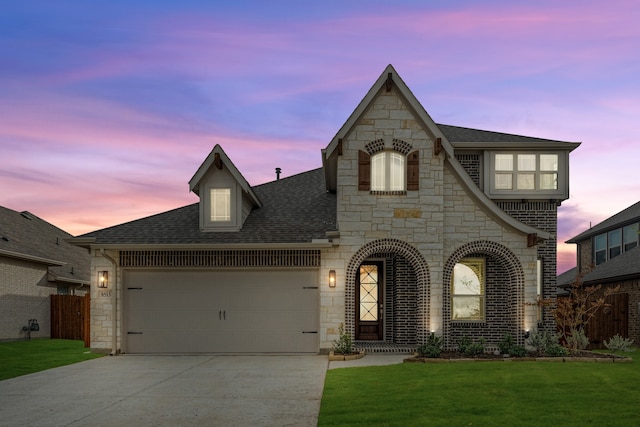 view of front of home featuring a lawn and a garage