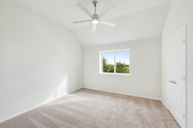 carpeted empty room featuring ceiling fan and vaulted ceiling