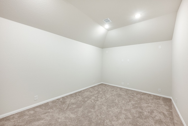 carpeted spare room with lofted ceiling