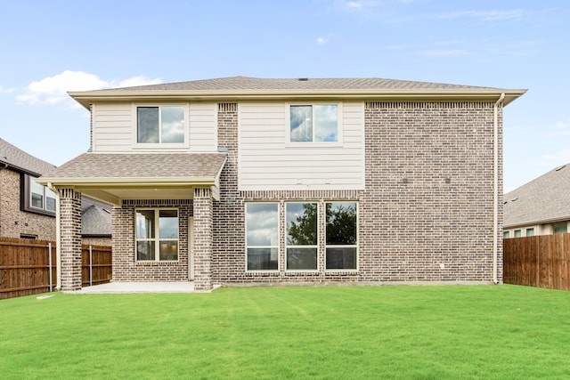 back of property featuring a lawn and a patio area