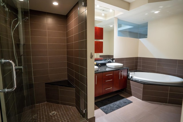 bathroom with tile patterned floors, vanity, and shower with separate bathtub