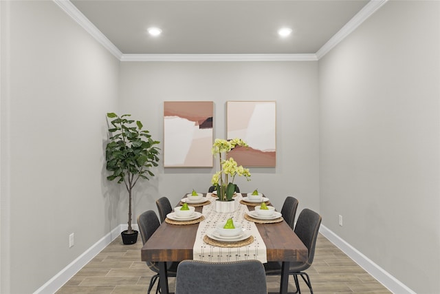 dining space featuring light hardwood / wood-style flooring and crown molding