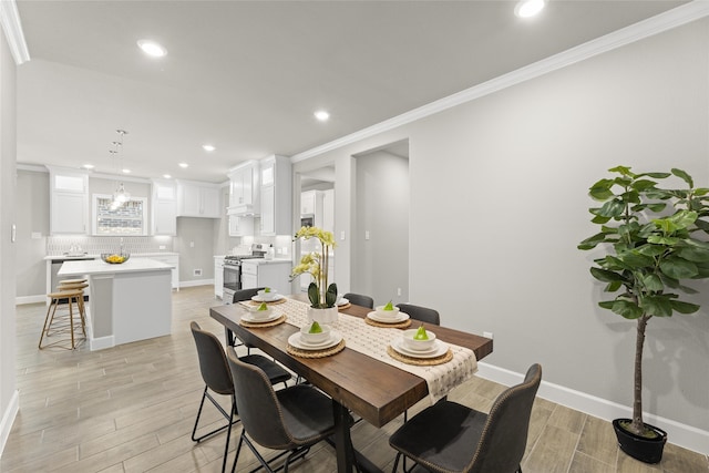 dining room featuring crown molding and light hardwood / wood-style floors