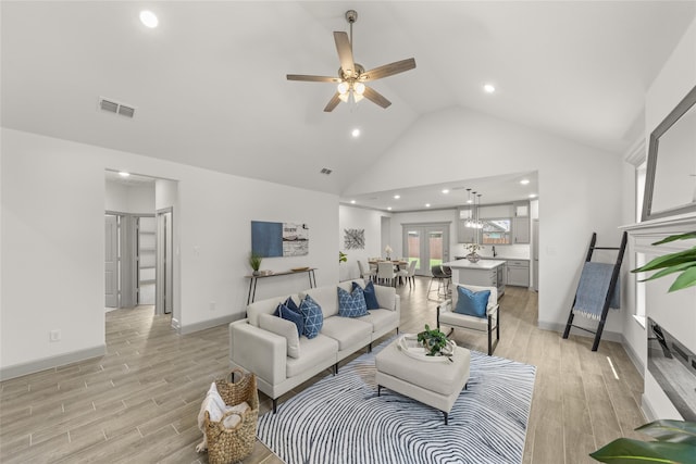 living room featuring high vaulted ceiling, ceiling fan, and light hardwood / wood-style floors