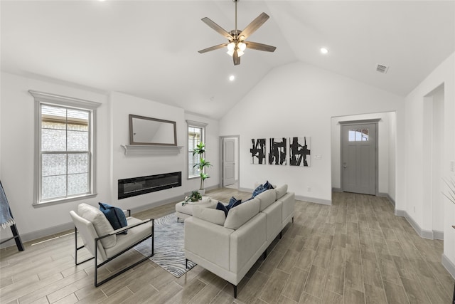 living room featuring ceiling fan, high vaulted ceiling, and light hardwood / wood-style floors