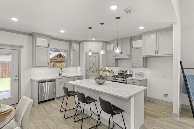 kitchen with decorative backsplash, stainless steel appliances, sink, and a kitchen island