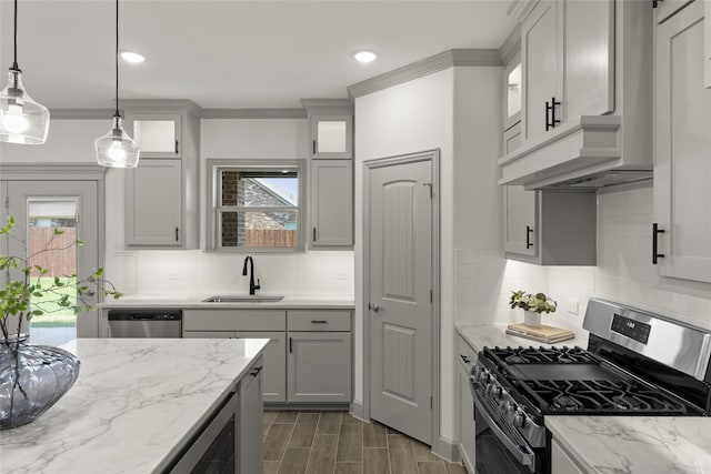 kitchen with sink, stainless steel appliances, decorative light fixtures, and decorative backsplash