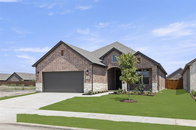 french country inspired facade with a garage and a front yard