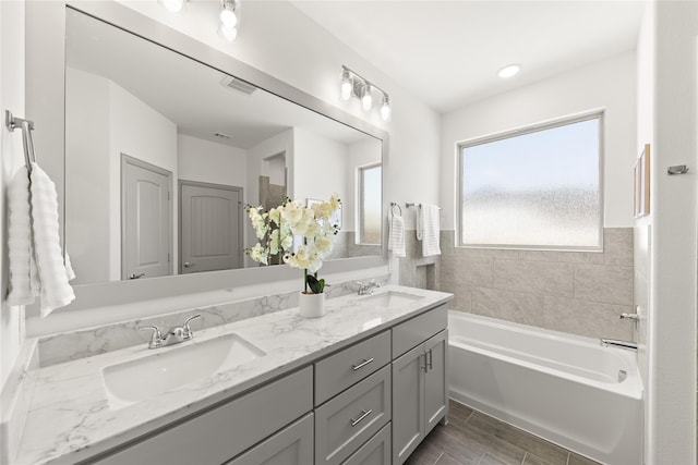 bathroom featuring double sink vanity, a tub, and tile patterned floors