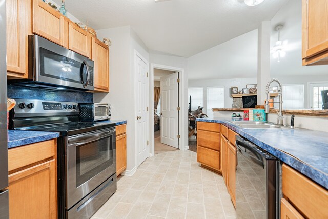 kitchen featuring appliances with stainless steel finishes, light tile patterned floors, a wealth of natural light, and sink