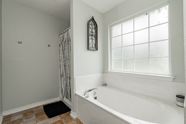 bathroom featuring shower with separate bathtub