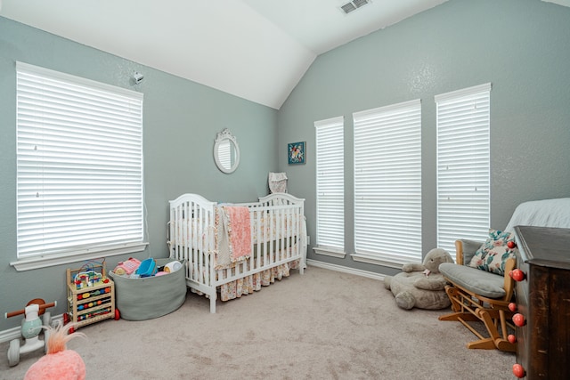 carpeted bedroom with vaulted ceiling, multiple windows, and a nursery area