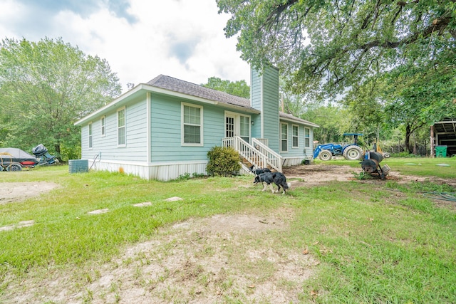 view of front of home featuring a front yard and central AC