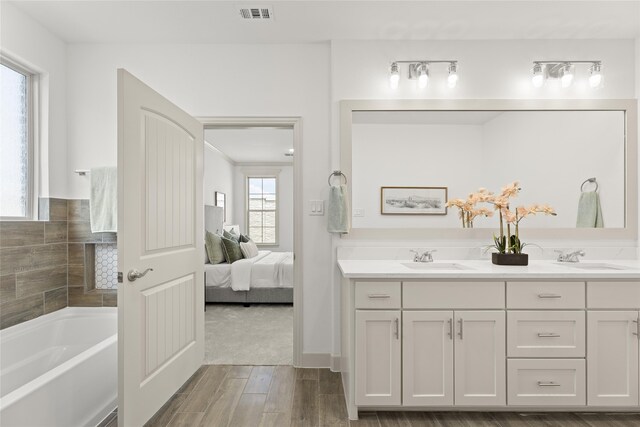 bathroom featuring a tub, hardwood / wood-style floors, and vanity