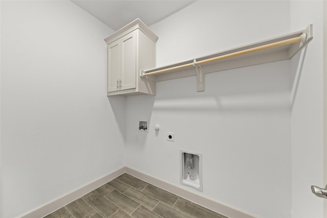 clothes washing area featuring hookup for a washing machine, hookup for a gas dryer, hookup for an electric dryer, dark hardwood / wood-style floors, and cabinets