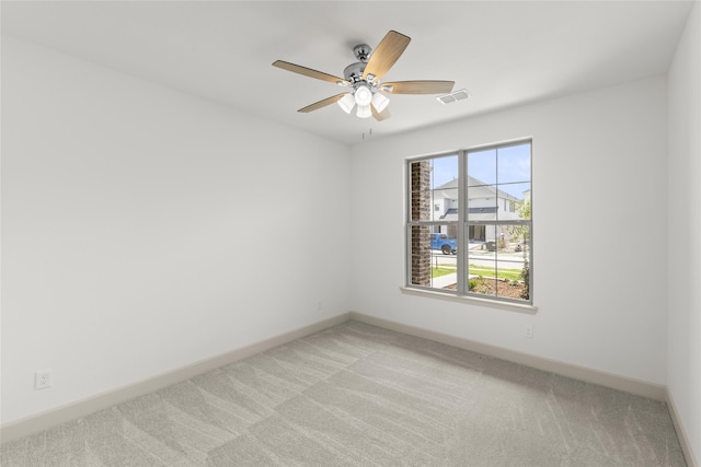 unfurnished room with light colored carpet and ceiling fan