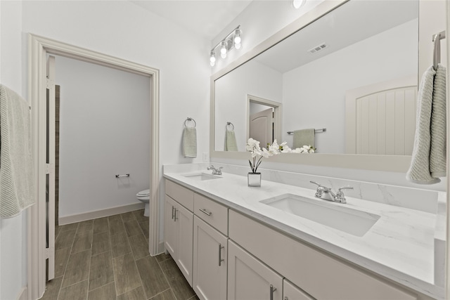 bathroom with vanity, toilet, and hardwood / wood-style floors