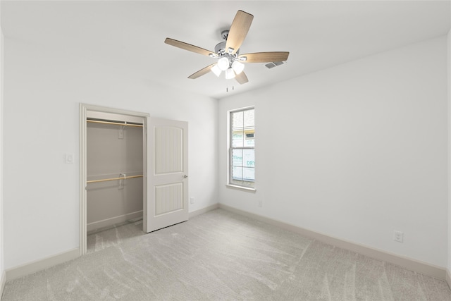 unfurnished bedroom with a closet, ceiling fan, and light carpet