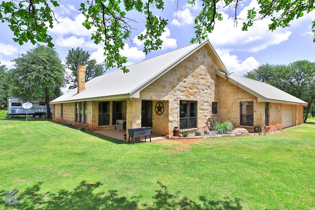 back of house with a garage, a yard, and a patio