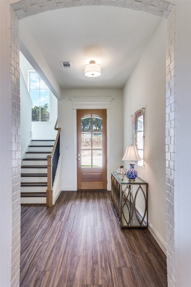 entryway with a textured ceiling, plenty of natural light, and dark hardwood / wood-style floors