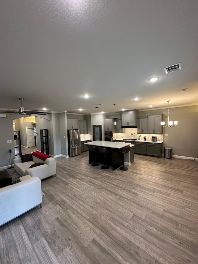 living room featuring ceiling fan with notable chandelier and hardwood / wood-style floors