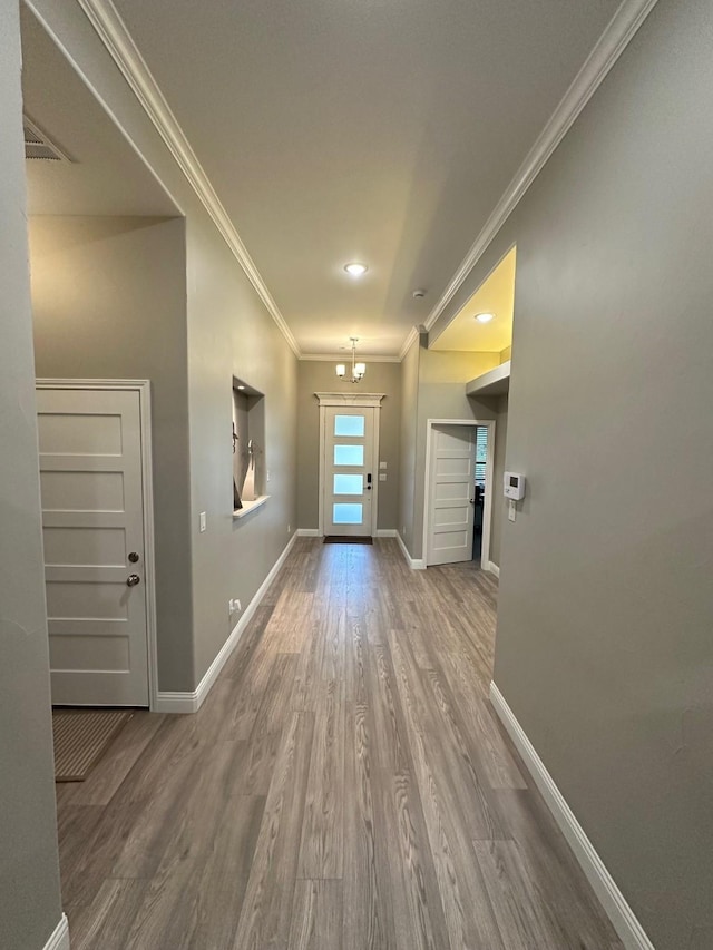 doorway to outside featuring hardwood / wood-style flooring and crown molding