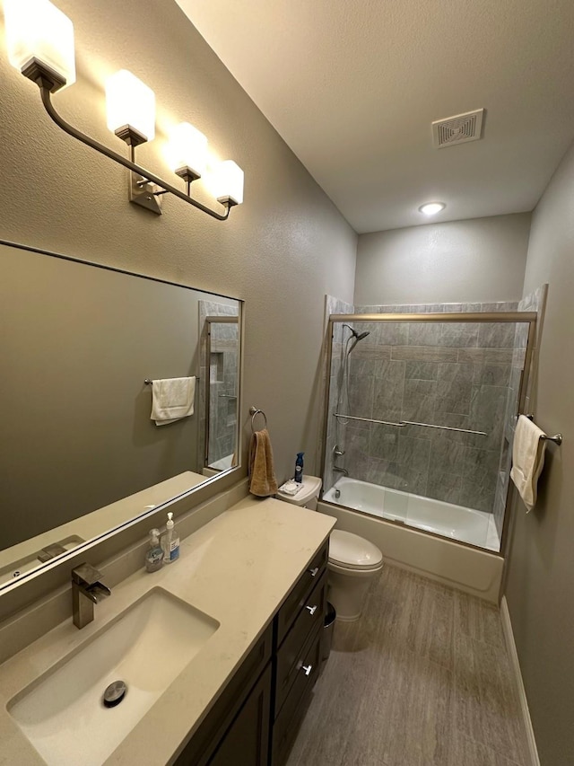 full bathroom featuring vanity, toilet, tiled shower / bath combo, and hardwood / wood-style flooring