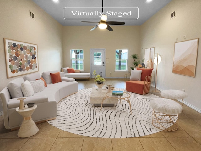 living room with tile patterned floors, ceiling fan, and a high ceiling