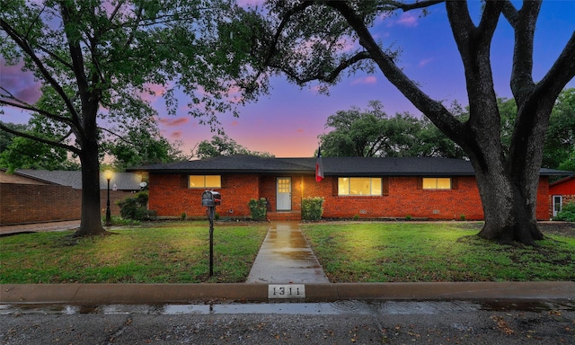 ranch-style home with a yard